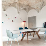 Table de réception Trigono avec piètement en bois teinté et plateau en marbre – Chaise design AVA colori bleu ciel Bross (profil)