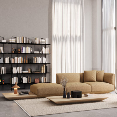 Modern living room with a tan modular sofa, tall black bookshelves, and a low wooden coffee table on a beige rug.
