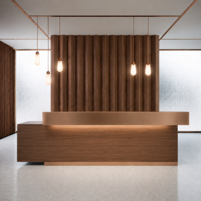 Modern wooden reception desk with copper accents in a contemporary lobby, hanging pendant lights, and vertical wood slats backdrop.